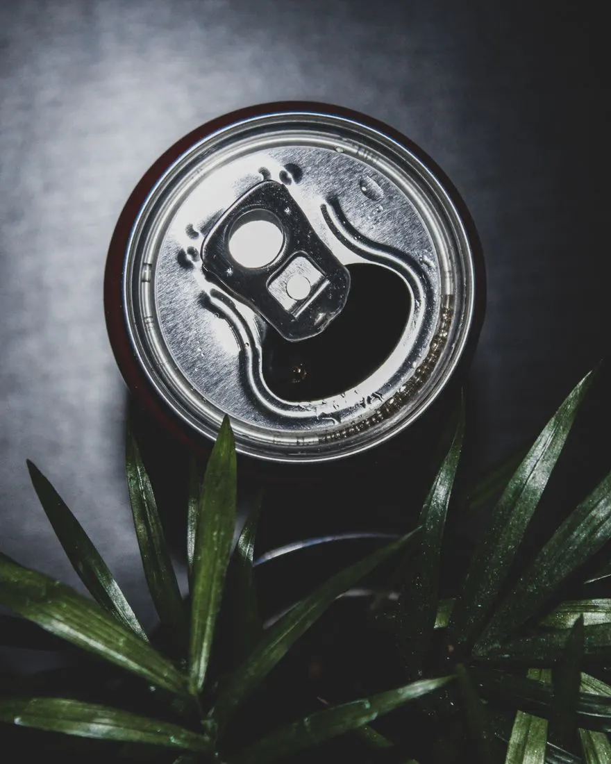 Open drink can photographed from above on a dark background